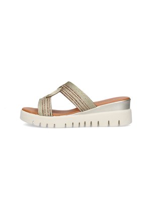 Sandalo beige slip-on con cinturini intrecciati a croce, sottopiede marrone e suola bianca spessa scanalata con leggero tacco a zeppa.