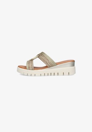 Sandalo beige slip-on con cinturini intrecciati a croce, sottopiede marrone e suola bianca spessa scanalata con leggero tacco a zeppa.