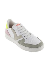 Baskets blanches avec un nez en suède gris, accents latéraux en "V" beige, talon rose, patch à la cheville jaune fluo et lacets blancs.