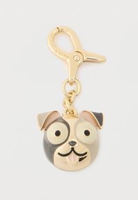 Kullattu metallinen koiran muotoinen avaimenperä, jossa on suuret silmät, musta ja ruskea kuviointi sekä irrotettava hummerilukko. Sileä pinta.