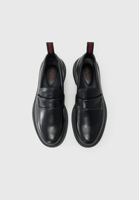 Sorte læderslippers med en glat tekstur, der har en frontrem og rød "HUGO" branding på hæltappen.