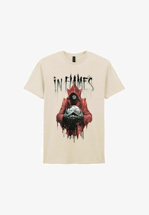 Beige cotton t-shirt featuring a black and red graphic of a cloaked figure holding a skull with white accents, and the text "IN FLAMES" above.