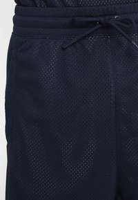 Mörkblå nätvävda shorts med justerbar dragsko i midjan och sidofickor.