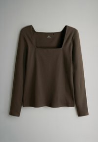 Braunes, geripptes Langarmoberteil mit quadratischem Ausschnitt und geradem Saum. Der Stoff hat eine strukturierte Oberfläche, die visuelles Interesse weckt.