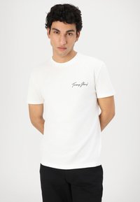 White short-sleeve cotton t-shirt featuring a black logo on the left chest. Crew neck design with a relaxed fit and smooth texture.