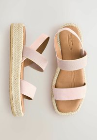 Roosa espadrille sandaalid, kus on kaks laia rihma, kootud jootu vahega ja siledast nahast tallapadi. Lame tald ja minimalistlik disain.