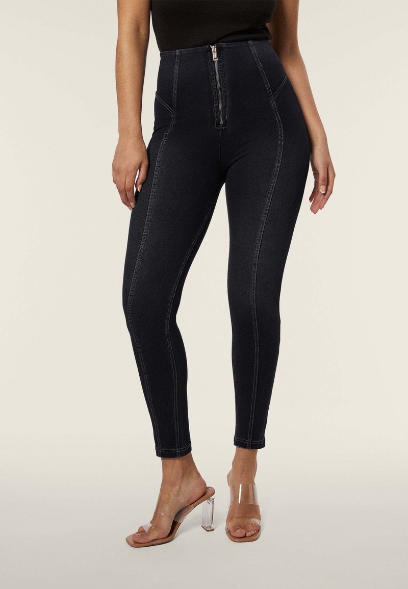 Leggings in denim scuro a vita alta con chiusura a zip sul davanti, caratterizzati da cuciture a contrasto e una vestibilità slim. Indossati con sandali trasparenti con tacco.