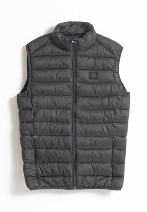 Chaleco de plumas negro con cuello alto, cremallera frontal y textura acolchada. Presenta aberturas laterales y un parche con el logo en el pecho.