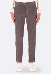 Pantaloni in velluto a coste grigi con righe verticali, design slim-fit, vita standard e chiusura con bottone, abbinati a sneakers bianche.