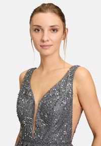 Graues Kleid mit tiefem V-Ausschnitt, verziert mit verstreuten Strasssteinen und floralen Akzenten, transparenten Seitenpaneelen und strukturiertem Stoff.