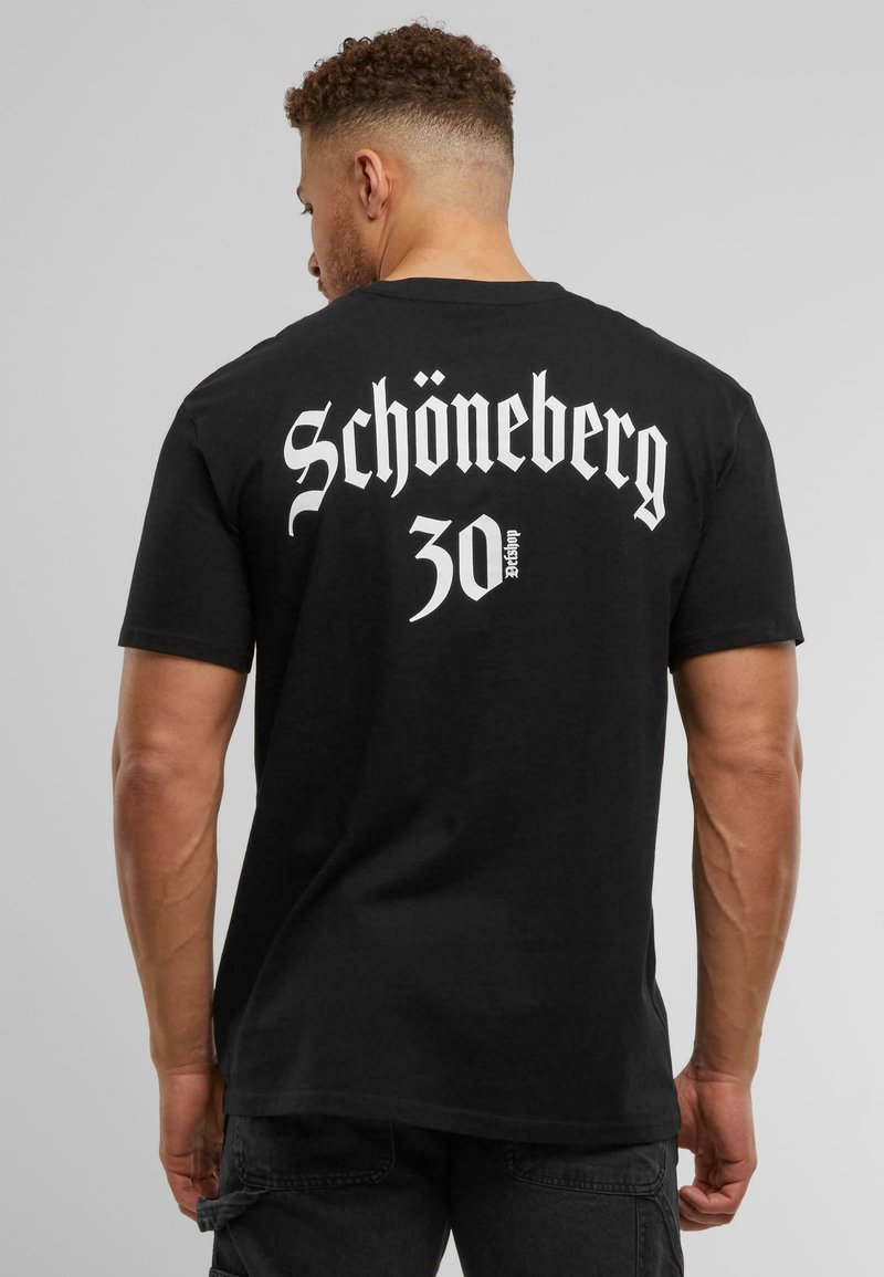 Sort bomulds t-shirt med stort hvidt gotisk tekst på ryggen, der siger "Schöneberg 30", med en løs pasform og korte ærmer.