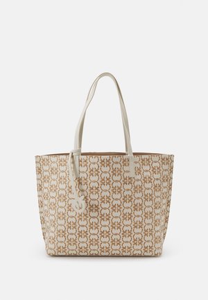 Beige og brun mønstret shoppertaske med to lange cremefarvede håndtag og et lille vedhæftet dekorativt mærke.
