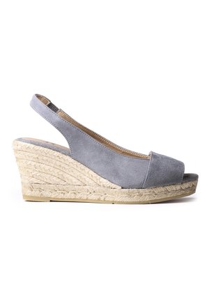 Sandalia de cuña con tiras traseras de ante gris, punta abierta y plataforma de yute trenzado, vista lateral sobre fondo blanco.