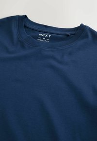 Marineblå crew-neck t-shirt lavet af glat bomuldsstof, med et regular fit mærkat på den indvendige hals.