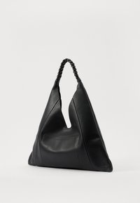 Black leather shoulder bag featuring a triangular shape, textured surface, and a braided handle. Notable for its unique cutout design.