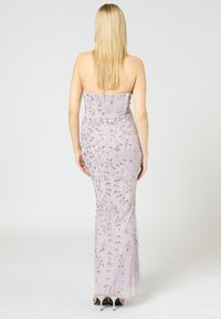 Abito da sera senza spalline color lilla con intricati ricami di perline e paillettes argentate, silhouette aderente e spacco alto fino alla coscia sul retro.