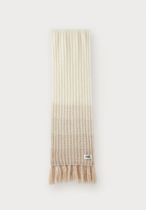 Strikket tørklæde med ribbet tekstur, der går fra cremefarvet til lys beige i bunden. Har bløde, frynset kanter og et mærke.