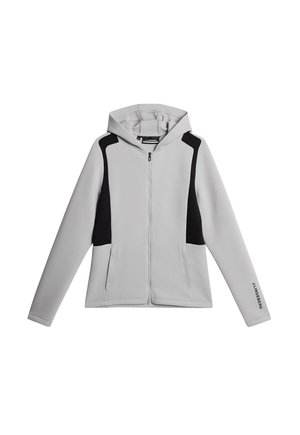 Felpa con cerniera grigia, con pannelli laterali neri e dettagli a contrasto. Presenta un cappuccio, tasche frontali e tessuto testurizzato. Elementi di design minimalista.