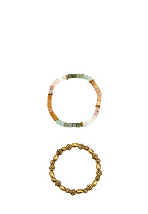 Dwie bransoletki z koralikami na białym tle; jedna z wielokolorowymi kwadratowymi koralikami i złotymi przekładkami, druga z teksturowanymi, złotymi okrągłymi koralikami.