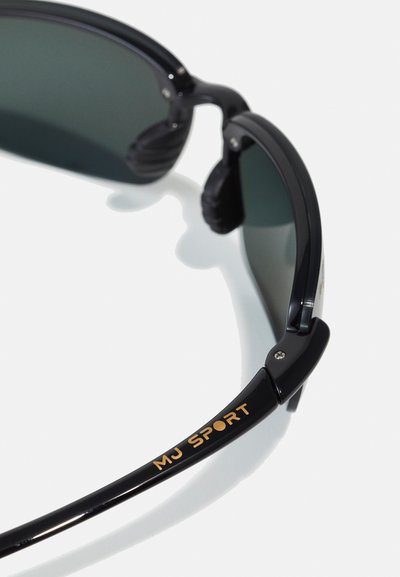Sunglasses with a black plastic frame, dark lenses, and gold "MJ SPORT" logo on the outer side of the arm. Textured ear grips included.