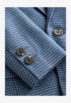 Mėlyna languota marškinių rankovės medžiaga su dviem rudos spalvos sagomis. Audinys austas subtilaus tinklelio raštu.