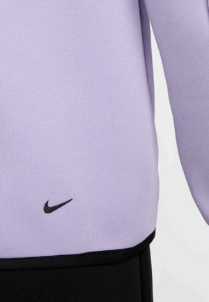 Lys lilla træningstop lavet af glat stof, med et sort Nike-logo i bunden og sorte detaljer ved sømmen.