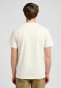 Light beige short-sleeve t-shirt with a round neck, made of smooth cotton fabric. Simple design, no visible patterns or accents.