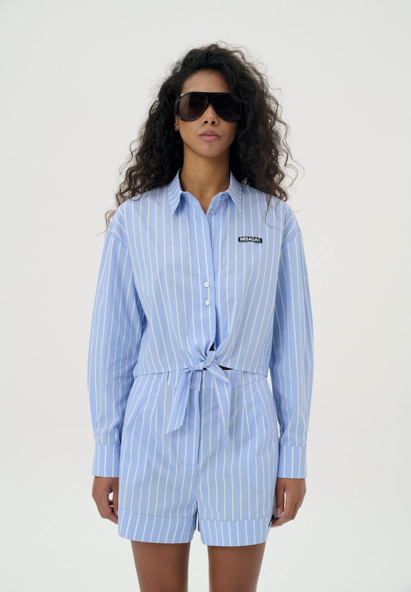 Blauw en wit gestreepte shirt met een vest voor, knoopsluiting en branding; gecombineerd met bijpassende shorts, heeft een ontspannen pasvorm.