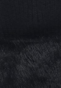 Tessuto in finta pelliccia nera con una texture morbida e liscia, caratterizzato da una leggera lucentezza e da fibre corte e dense su tutta la superficie.