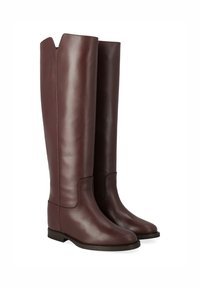 Bottes en cuir bordeaux jusqu'aux genoux, avec une texture lisse, une légère brillance et une fermeture éclair sur le côté, dotées d'une semelle plate et d'un design minimaliste.