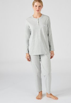 Haut de pyjama gris à manches longues avec trois boutons et une poche, associé à un pantalon gris à pois. Tissu doux, coupe décontractée.