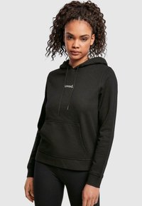 Black hoodie featuring a front pocket, drawstring, and the word "loved." embroidered in white on the chest. Soft, textured material.