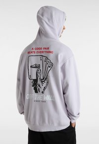 Light purple hoodie featuring a graphic print of a hand holding playing cards on the back, with text and "Vans" logo.
