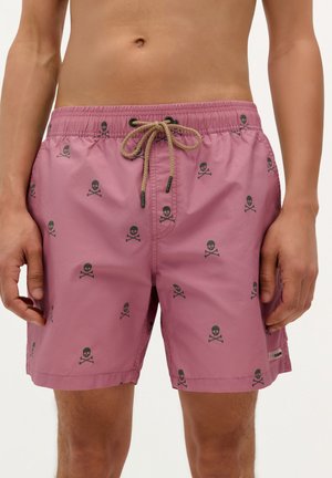 Shorts de bain rose en tissu léger, ornés d'un motif de skull et os croisés noir, avec un cordon de serrage réglable et une poche latérale.