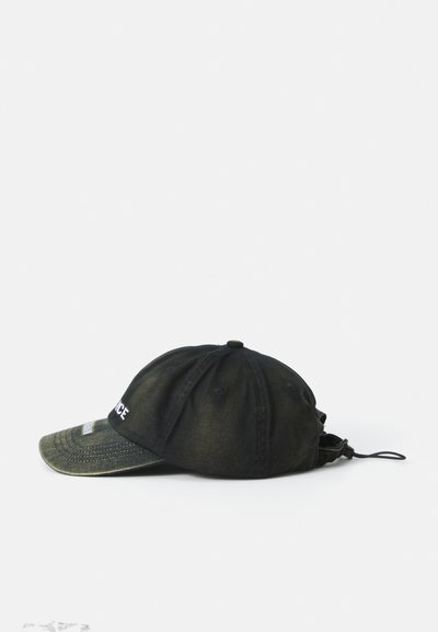 Black cap made of faded fabric, featuring a curved brim, a stitched logo, and an adjustable strap at the back. Textured, casual design.