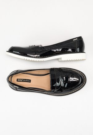 Par sorte laklæder loafers med hvide såler, den ene vist fra siden og den anden oppefra.