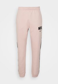 Rosa sweatpants med svart Nike-logotyp och sidostrand, tillverkad av mjukt tyg, med elastisk midja och avslutade anklar.