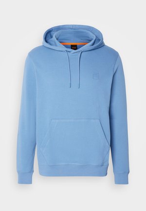 Blue hooded sweatshirt made of soft fabric, featuring a front kangaroo pocket, tonal logo patch, and drawstring at the hood.