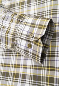 Mehrfarbige Karoshemd in Braun, Weiß, Gelb und Lila mit einem knöpfbaren Manschette und glatter Textur. Zwei sichtbare Messingknöpfe.