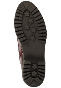 Semelle en caoutchouc noire d'une chaussure avec des sculptures en forme de fleur et des rainures épaisses, taille 37 visible sur la zone du talon.