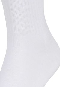 Chaussette en coton blanc de type crew avec une texture côtelée, dotée d'un talon et d'une pointe renforcés pour plus de durabilité, se rétrécissant de la mollet à la cheville.