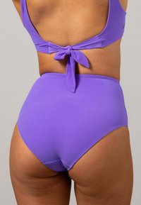 Lila bikinitopp med knytning i ryggen, matchad med högmidjade lila bikinitrosor. Slätt, elastiskt tyg i en enfärgad nyans.