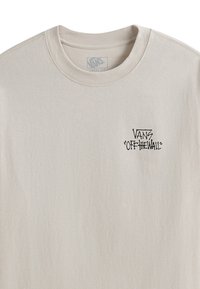 Camiseta de manga larga color beige, hecha de algodón, con un cuello redondo y un logo impreso en negro "VANS 'Off the Wall'" en el pecho.