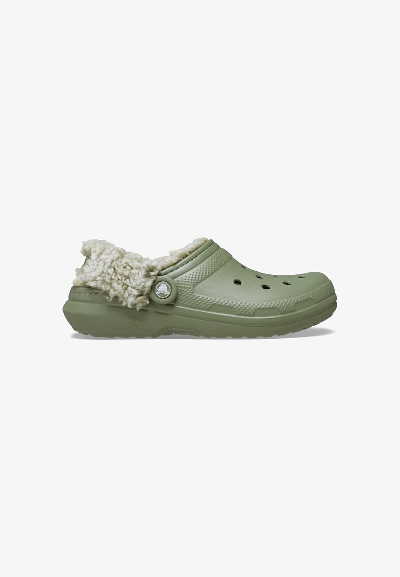 Sabot vert clair à enfiler avec des trous de ventilation et une doublure en fourrure blanche douce autour du talon et à l'intérieur, présenté de côté sur fond blanc.