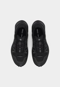 Ζευγάρι μαύρα παπούτσια για ορεινό τρέξιμο Salomon με κορδόνια γρήγορης έλξης και εσωτερικά πέλματα Ortholite, εμφανιζόμενα από το πάνω μέρος σε λευκό φόντο.