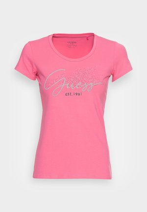 T-shirt rose à manches courtes avec logo "Guess" en paillettes argentées et texte "EST. 1981" sur le devant, col rond, style ajusté.