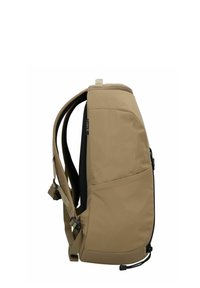 Sac à dos beige présentant un design épuré, des bretelles rembourrées, une poche latérale et une finition en tissu texturé. Cordon de serrage ajustable à la base.
