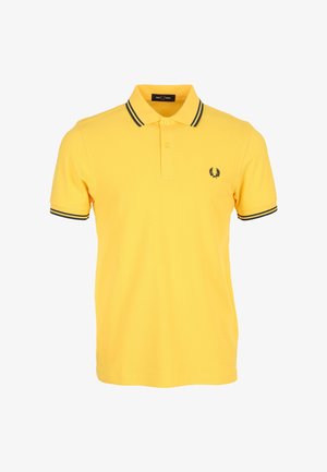 Geel poloshirt met korte mouwen, zwarte dubbele strepen op de kraag en mouwen, twee knopen en een klein zwart lauwerkranslogo op de borst.