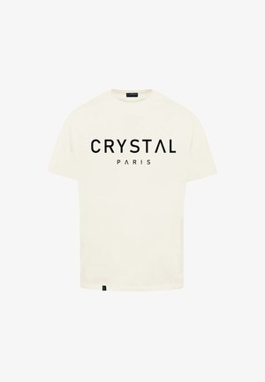 Krémové bavlněné tričko s krátkými rukávy, s tučným černým nápisem "CRYSTAL PARIS" na přední straně a malým logem na spodním lemu.