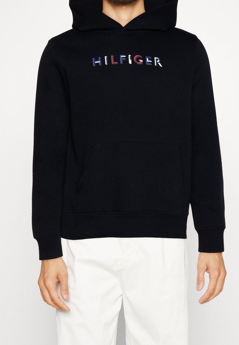Felpa nera con tasca frontale, caratterizzata dal logo "HILFIGER" multicolore. Realizzata in tessuto morbido con polsini e orlo a costine.